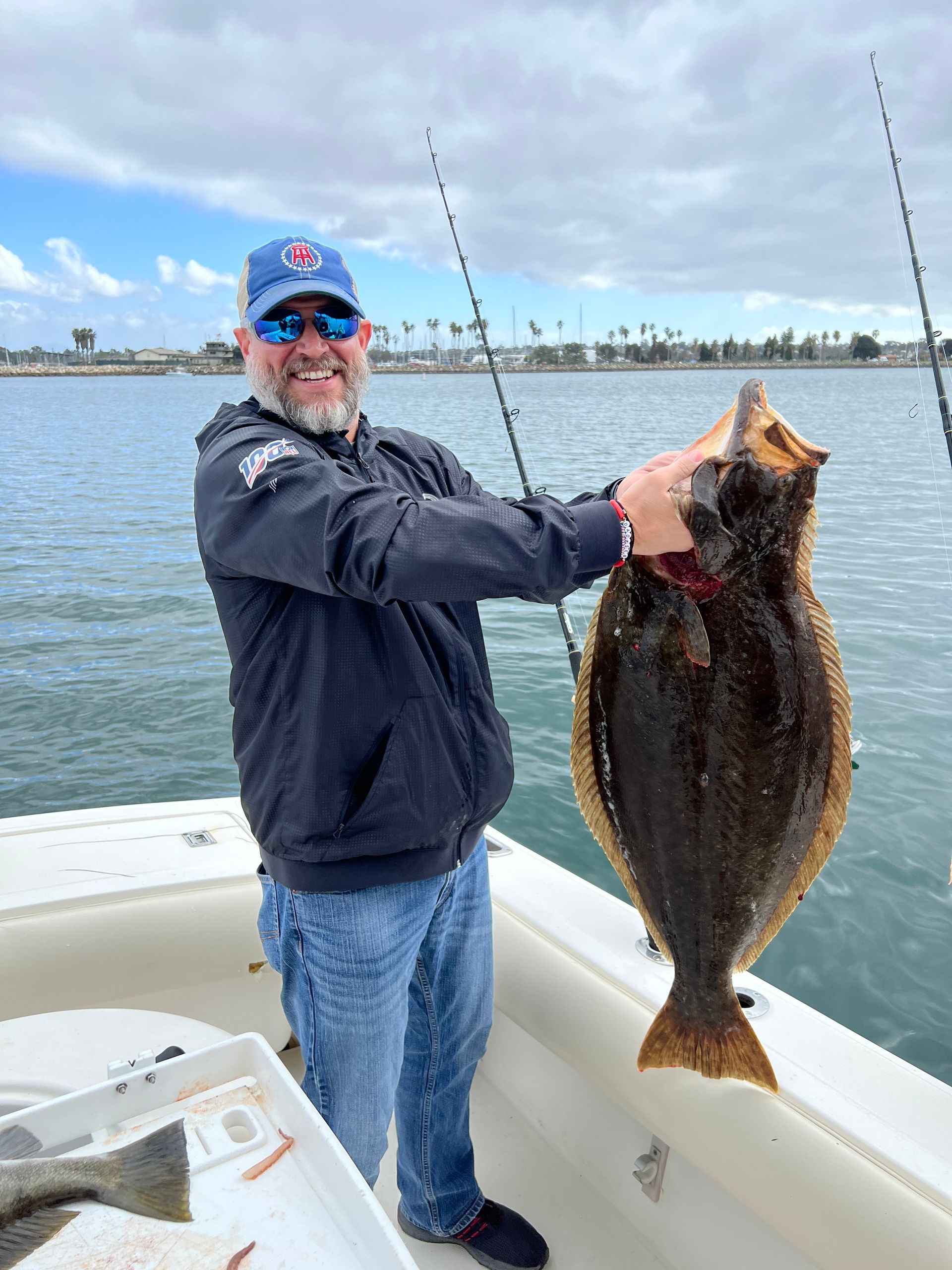 A man is holding a large fish on a boat.