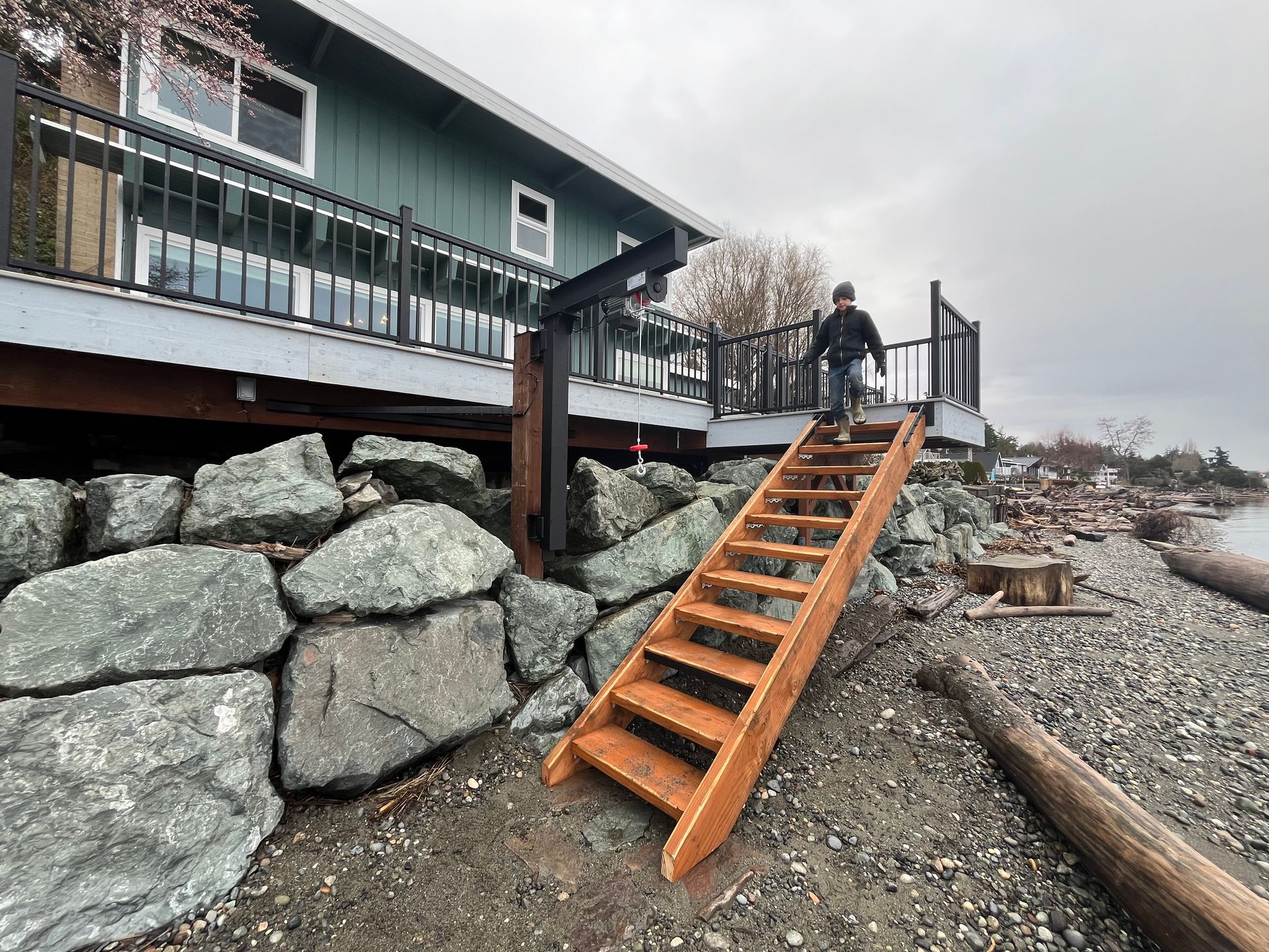 A man is walking up a set of wooden stairs to a house.