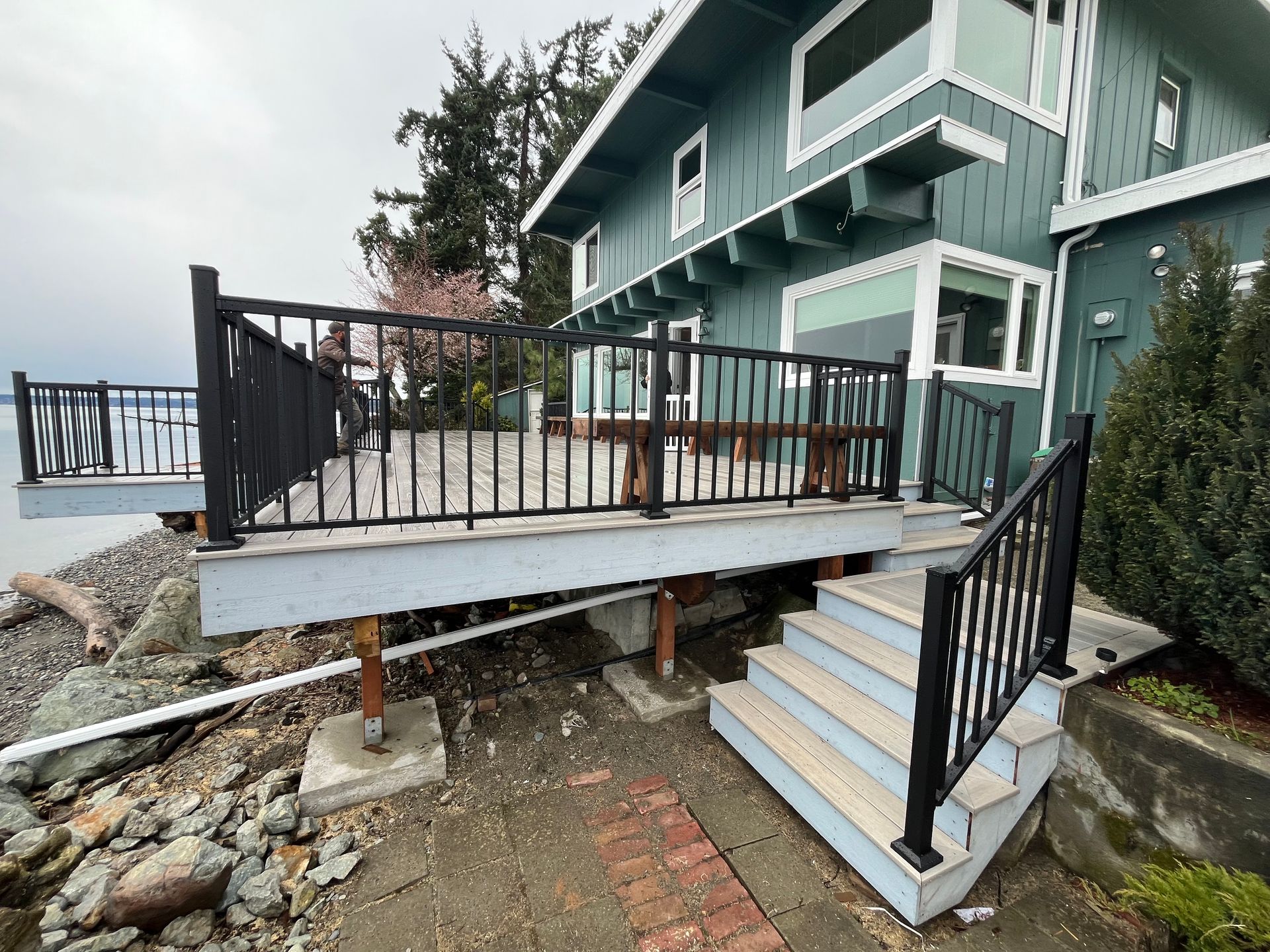 A house with a deck and stairs on the side of it.