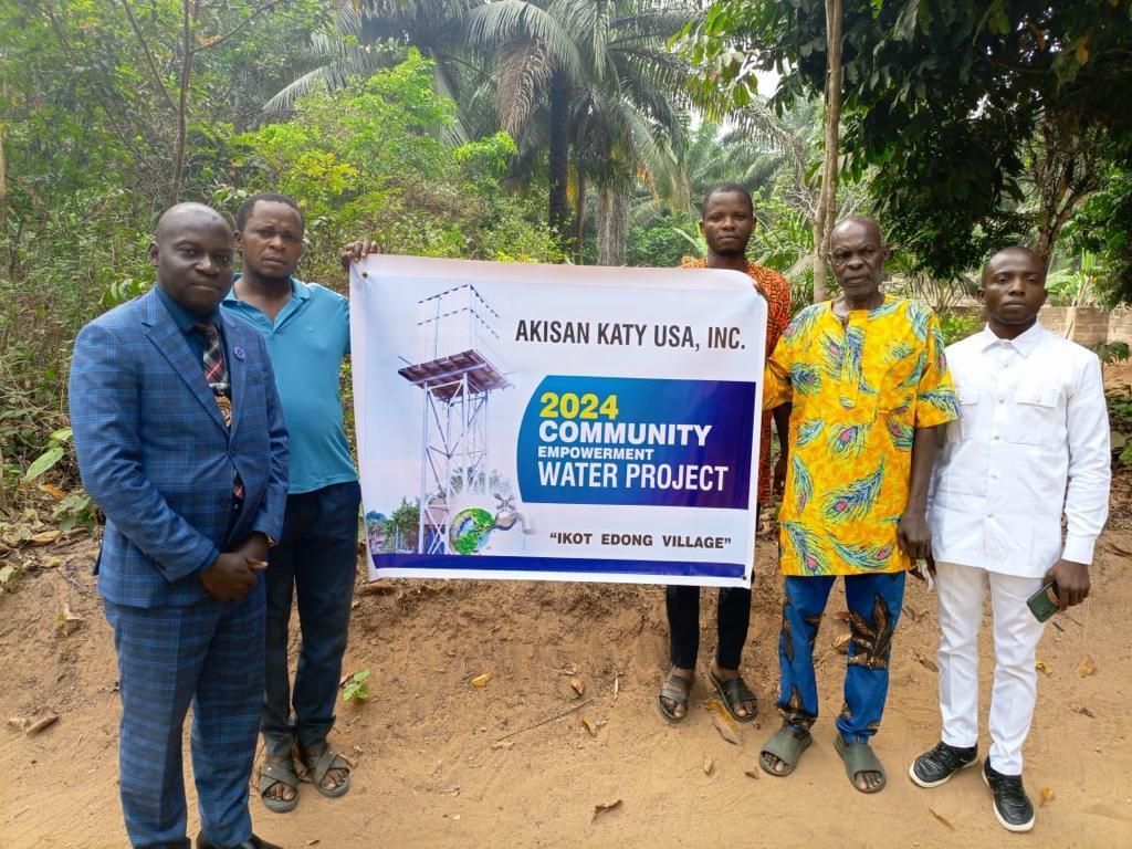 A man in a blue suit and red tie is standing at a podium giving a speech