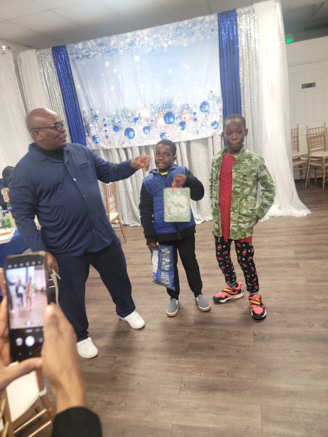 A man is standing next to two young boys in a room.