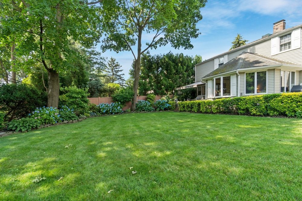 A large lush green lawn in front of a house.