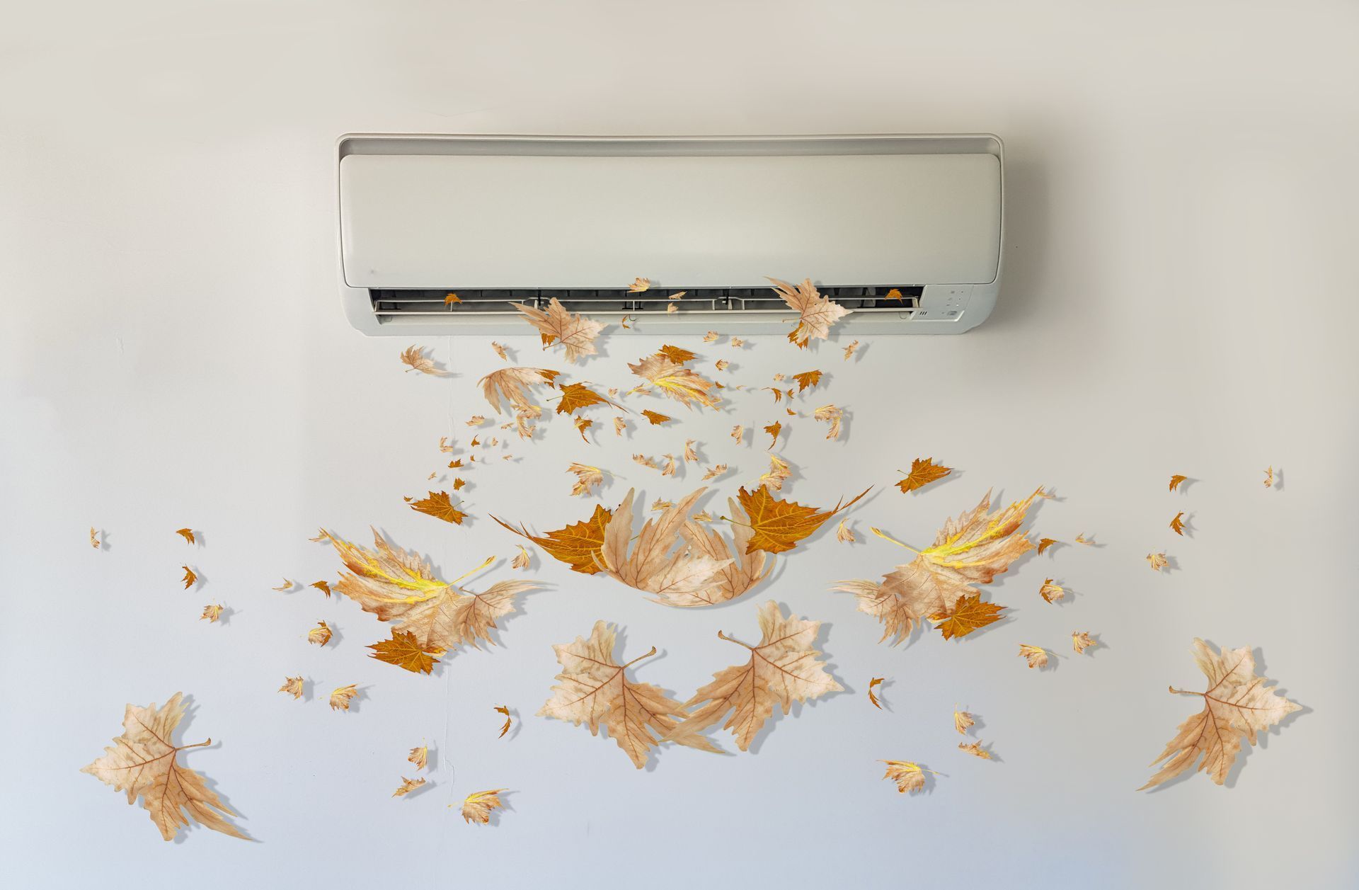 Leaves are flying out of an air conditioner on a wall.
