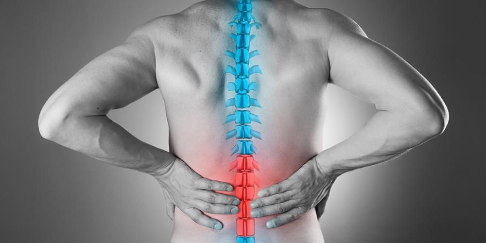 Person with hands on lower back, spine highlighted in blue and red, suggesting pain.