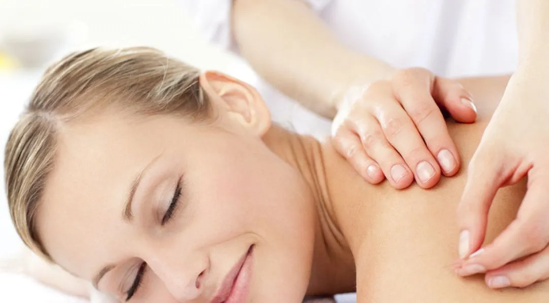 Woman receiving acupuncture on her shoulder, eyes closed with a calm expression.