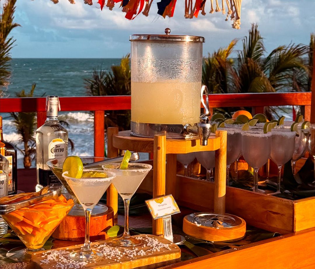 Uma grande piscina cercada por cadeiras e palmeiras em um dia ensolarado.