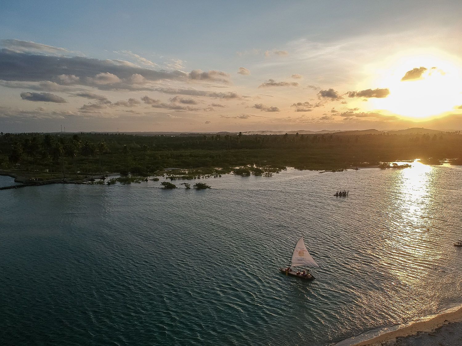 Uma vista aérea de um corpo de água com barcos ao pôr do sol