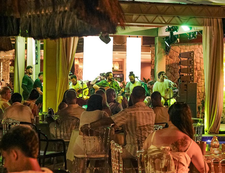 Uma grande piscina cercada por cadeiras e palmeiras em um dia ensolarado.