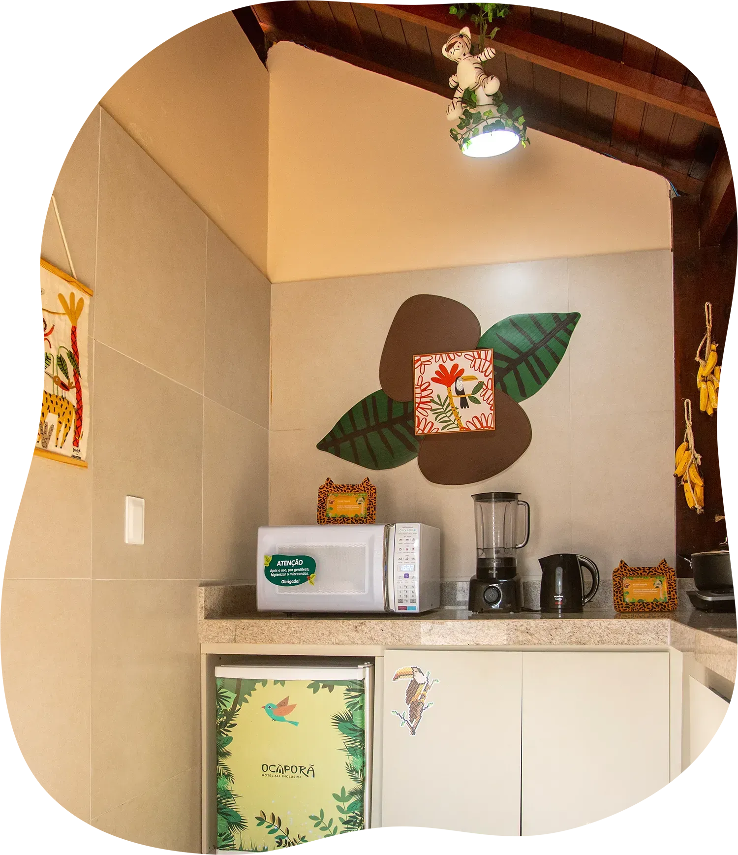 Uma cozinha com um micro-ondas, um liquidificador e uma geladeira