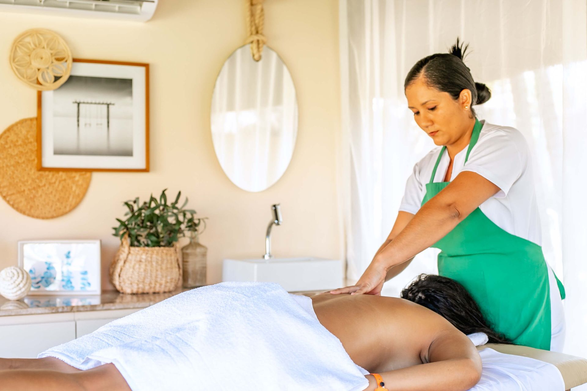 Uma mulher está fazendo uma massagem em um homem em uma mesa de massagem.