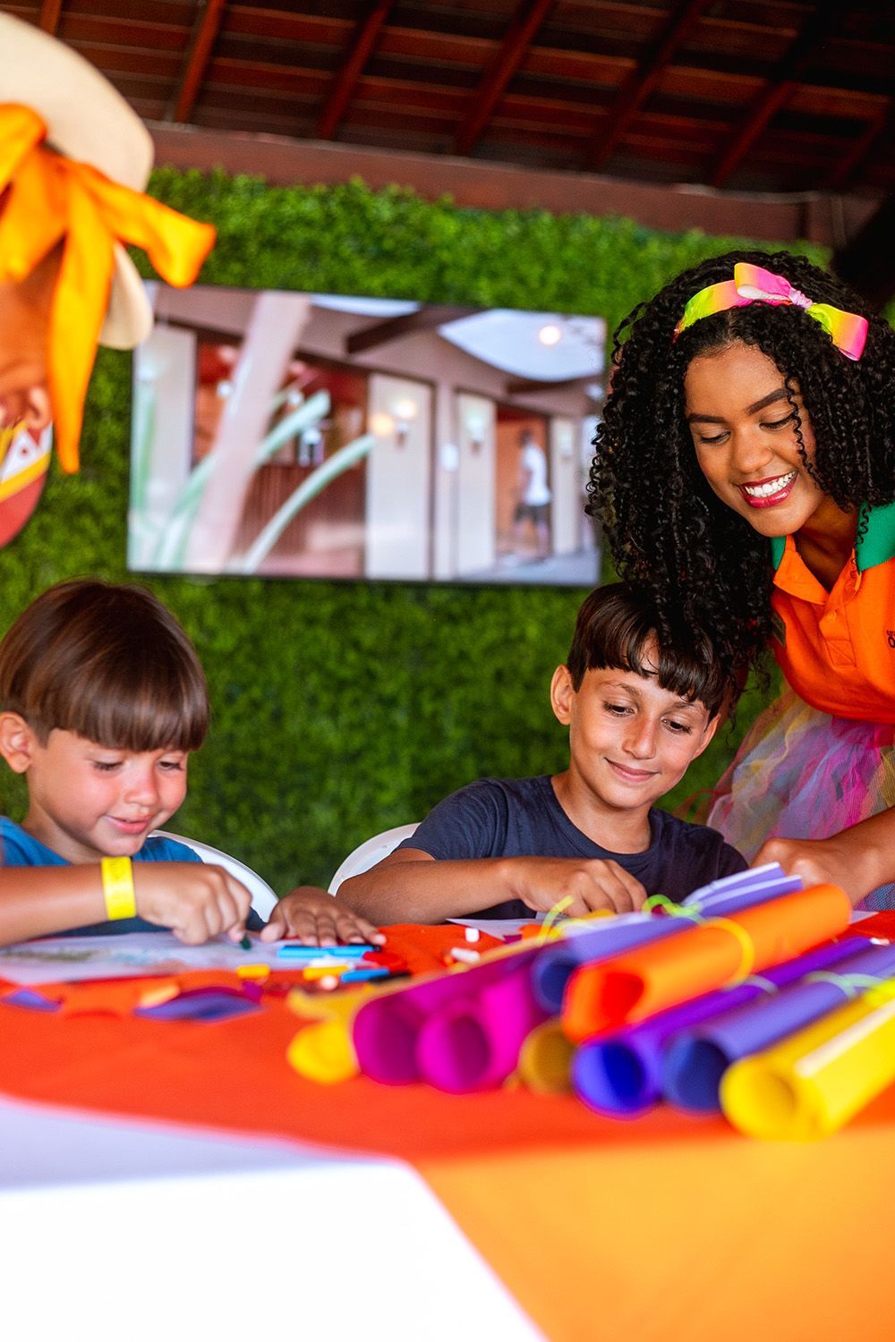 Um grupo de crianças está sentado à mesa com um palhaço.