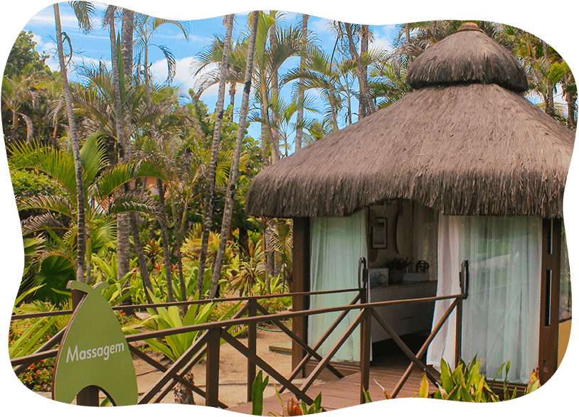 Uma pequena cabana com telhado de palha cercada por palmeiras.