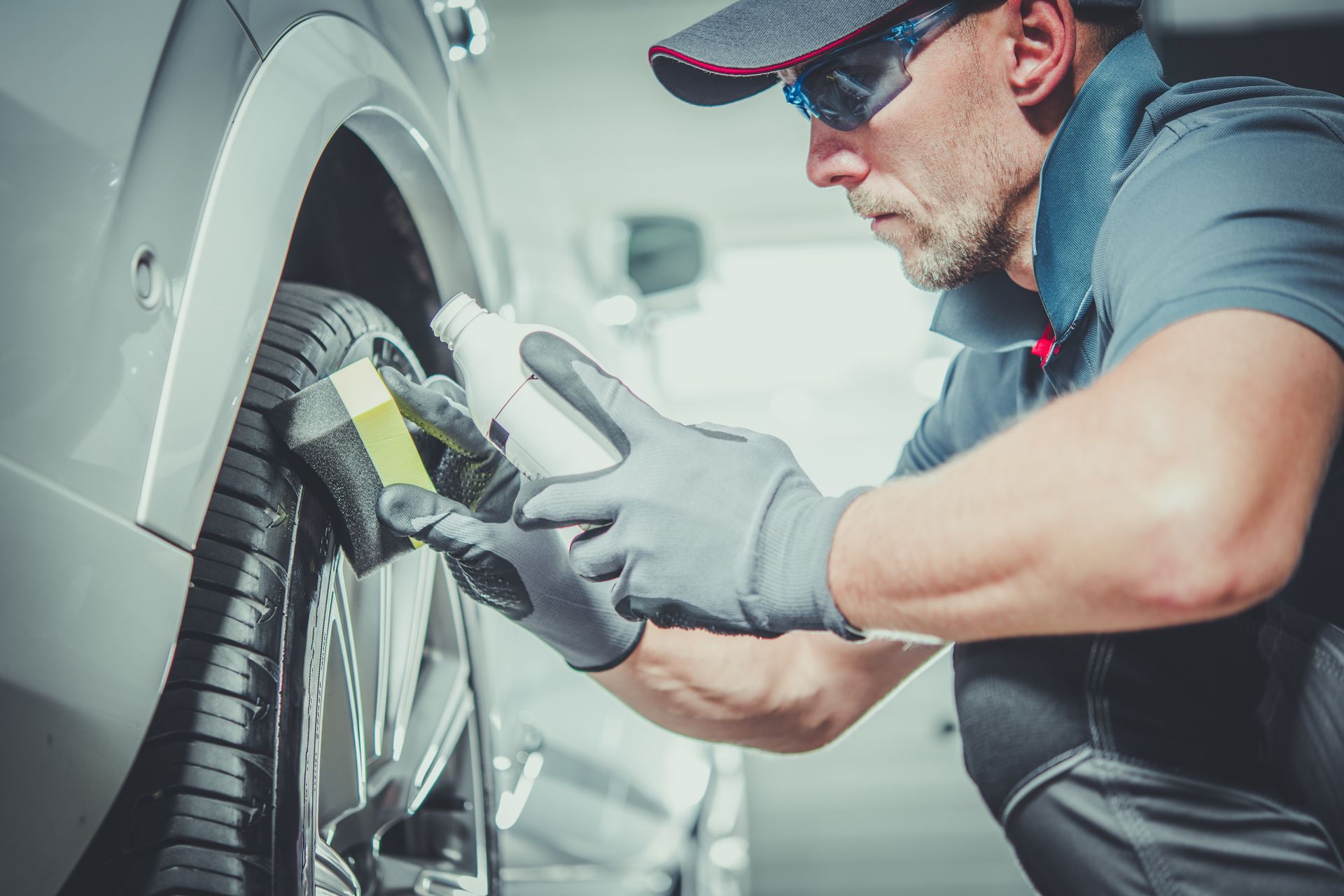 A man is polishing a tire on a car.