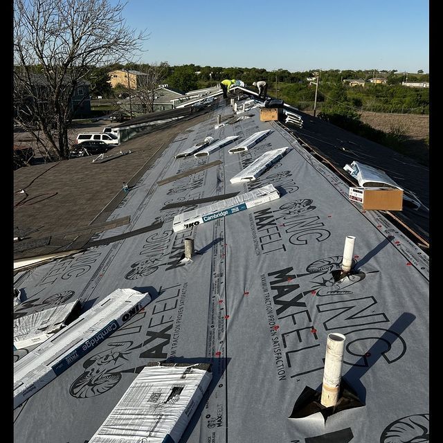 A roof is being covered with a roofing material that says ' ns maxell ' on it