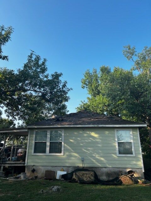 A small house with a roof that is covered in shingles