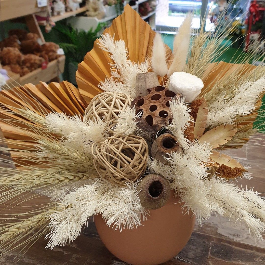 A Woman is Holding Two Wrist Flowers in Her Hands — The Flower Station Townsville In Kirwan, QLD A Woman is Holding Two Wrist Flowers in Her Hands — The Flower Station Townsville In Kirwan, QLD