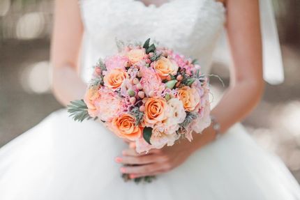 A Bride in a Wedding Dress is Holding a Bouquet of Flowers — The Flower Station Townsville In Kirwan, QLD