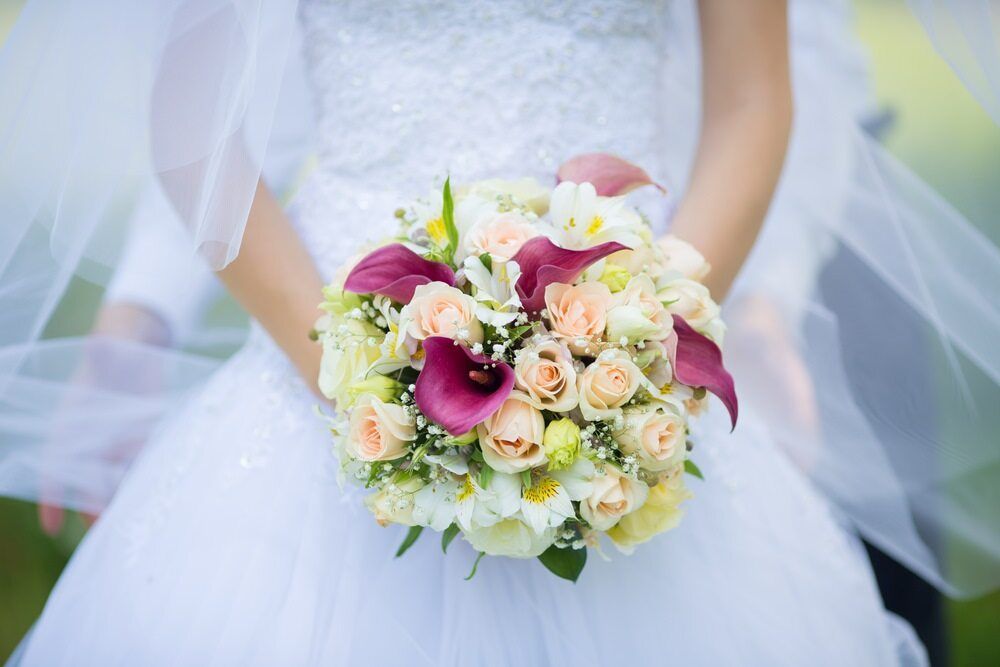 The Bride is Holding a Bouquet of Flowers in Her Hands — The Flower Station Townsville In Kirwan, QLD The Bride is Holding a Bouquet of Flowers in Her Hands — The Flower Station Townsville In Kirwan, QLD