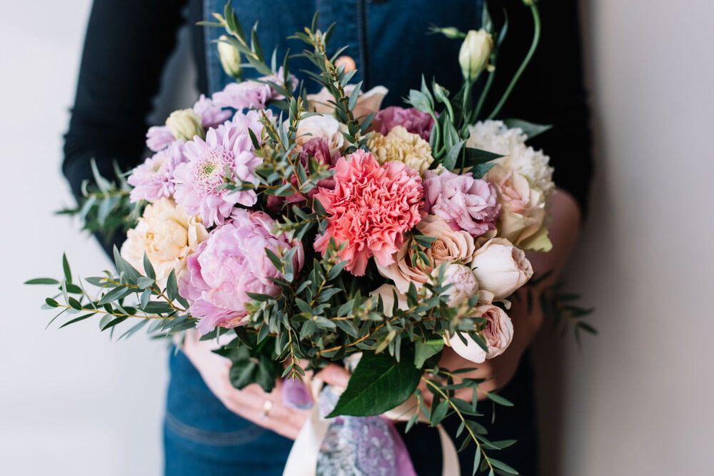 A Woman is Holding a Bouquet of Flowers in Her Hands — The Flower Station Townsville In Kirwan, QLD