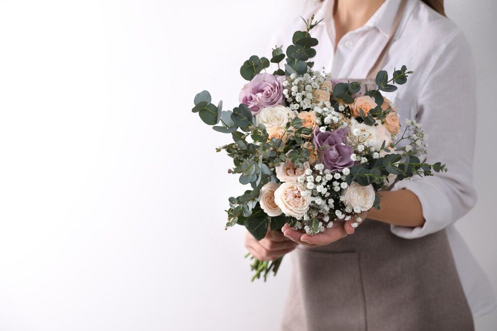 A Woman is Holding a Bouquet of Flowers in Her Hands — The Flower Station Townsville In Kirwan, QLD