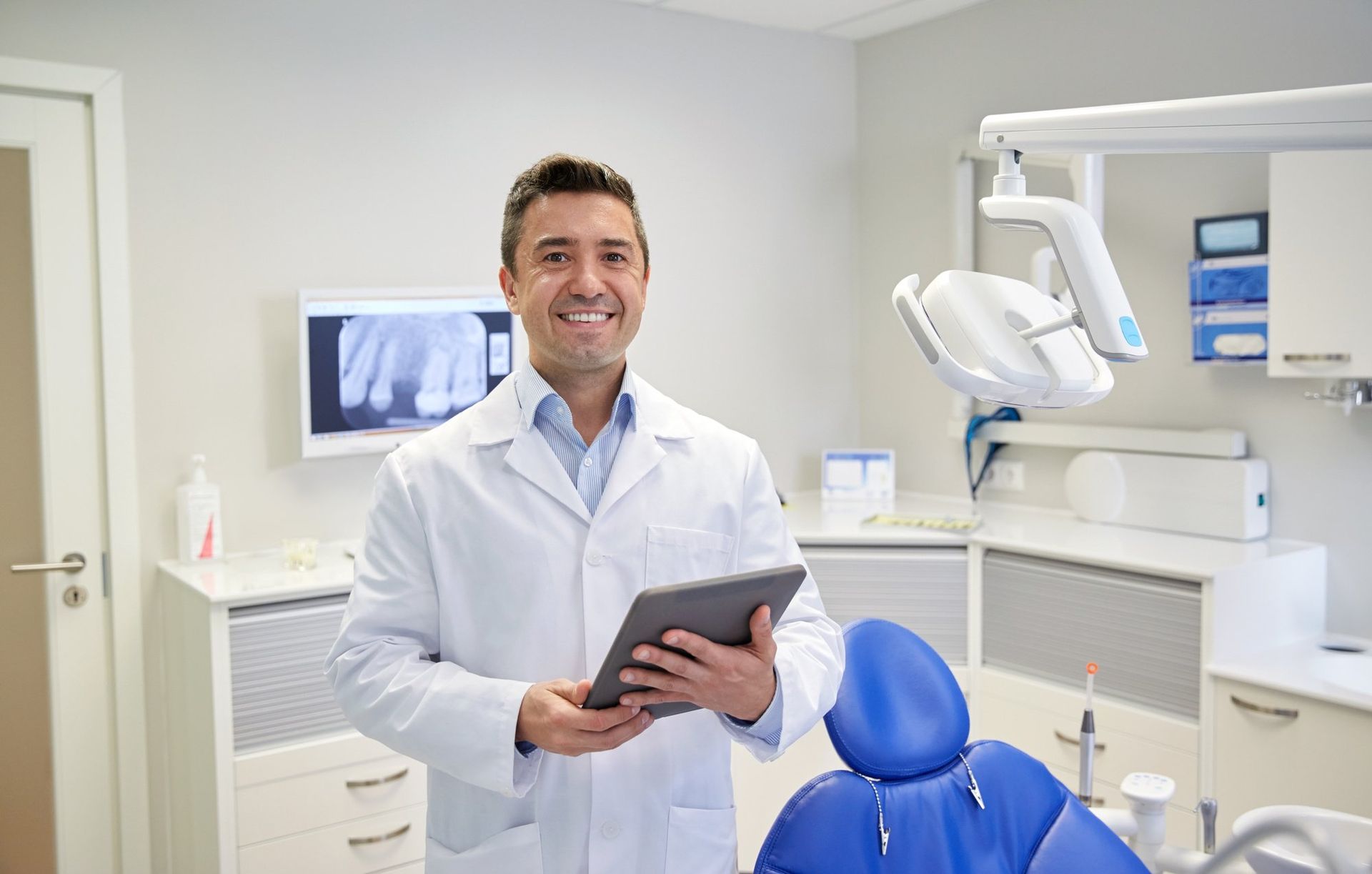 Dentist smiling and standing in dental room