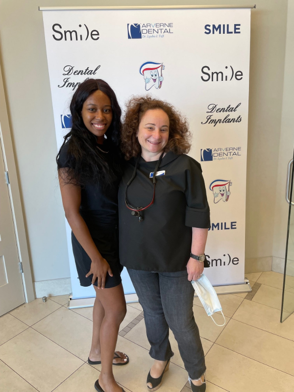 Two women smiling in front of a 