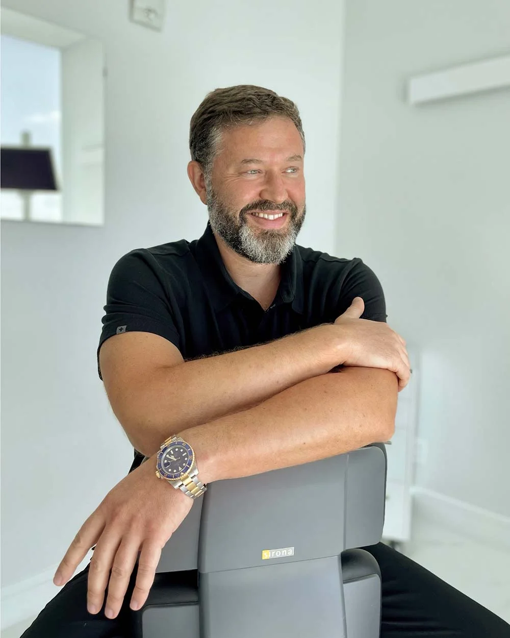 A man is giving a woman a piggyback ride and they are smiling for the camera.