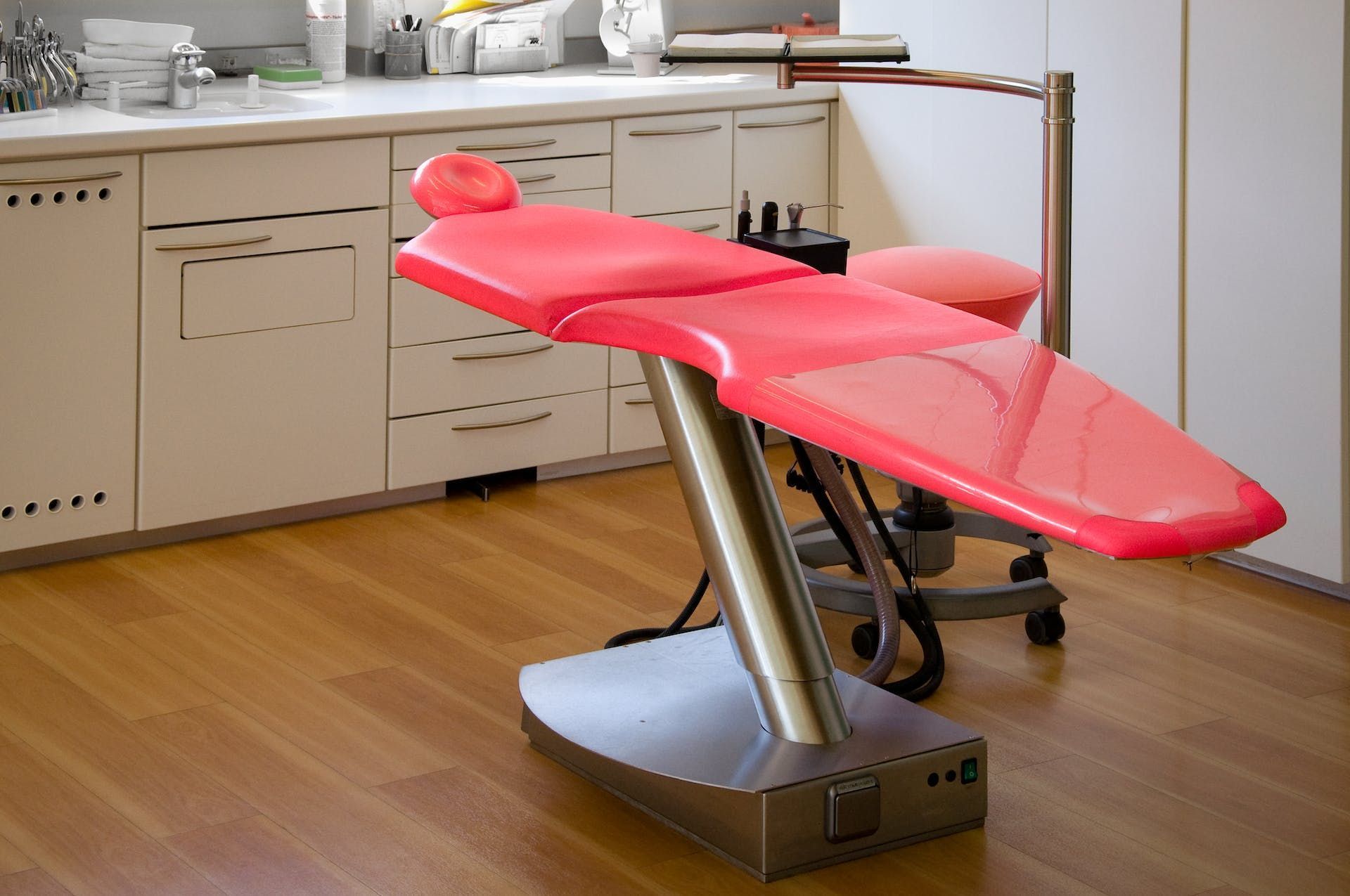 a red dental chair sits in a dental office