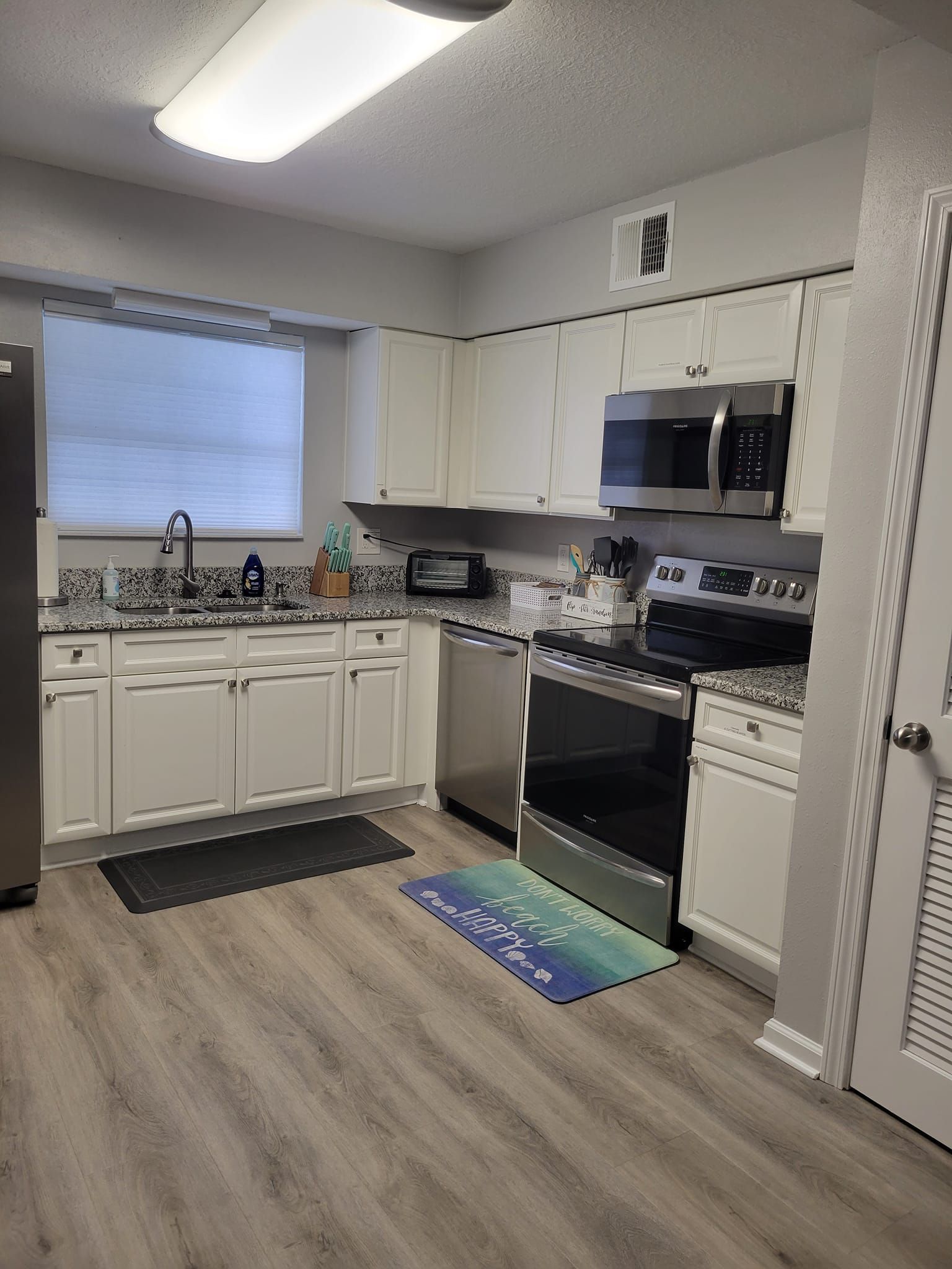 A kitchen with white cabinets and stainless steel appliances