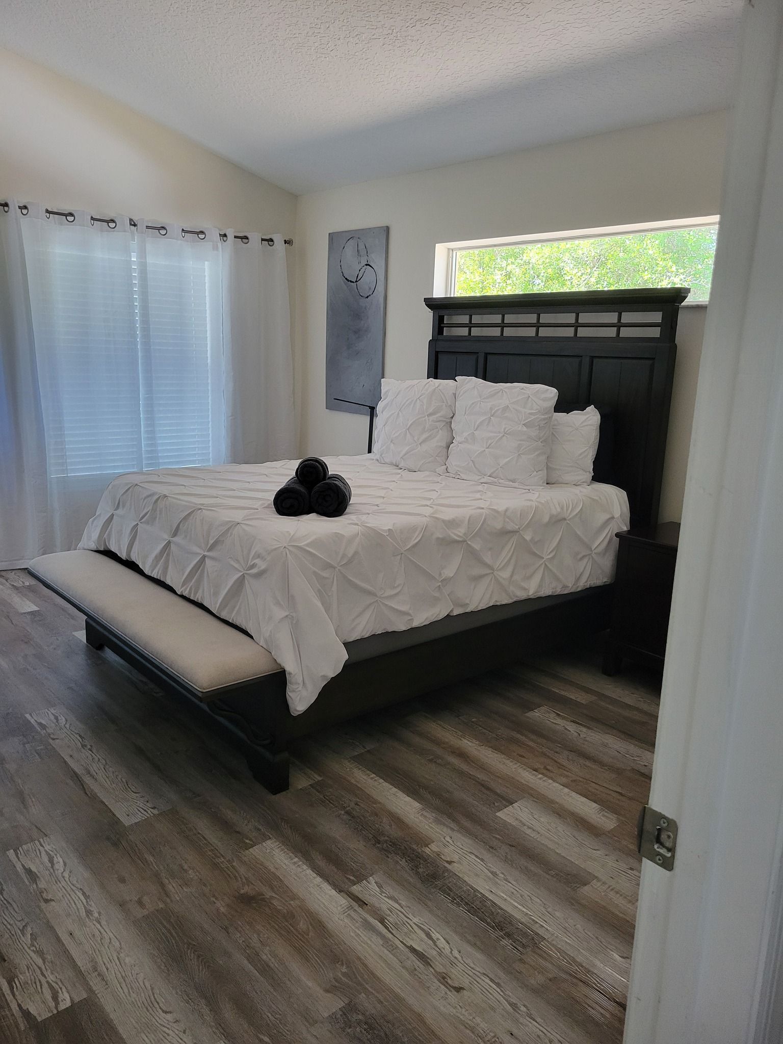 A bedroom with a bed , nightstand , and window.