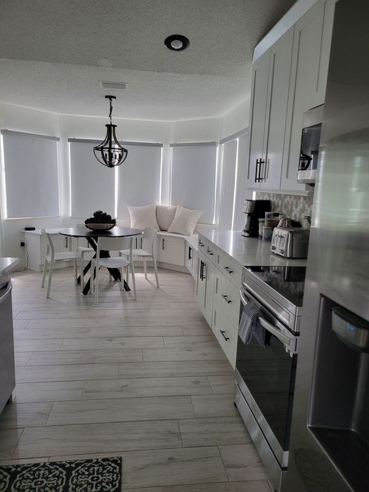 A kitchen with white cabinets and stainless steel appliances
