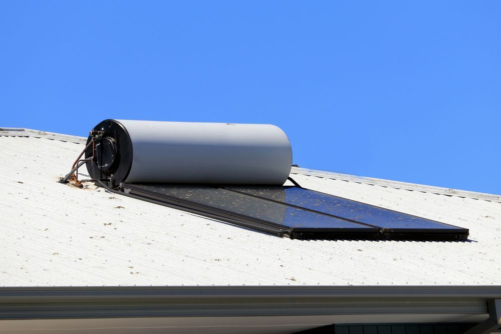 Rolled-up Solar Panel on a White Rooftop Under a Clear Blue Sky — New Gen Plumbing and Gas in Banora Point, NSW