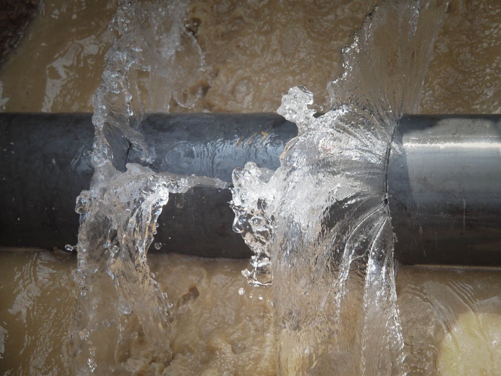 Water Leaking From a Black Pipe, Splashing Against a Wet Wall — New Gen Plumbing and Gas in Banora Point, NSW