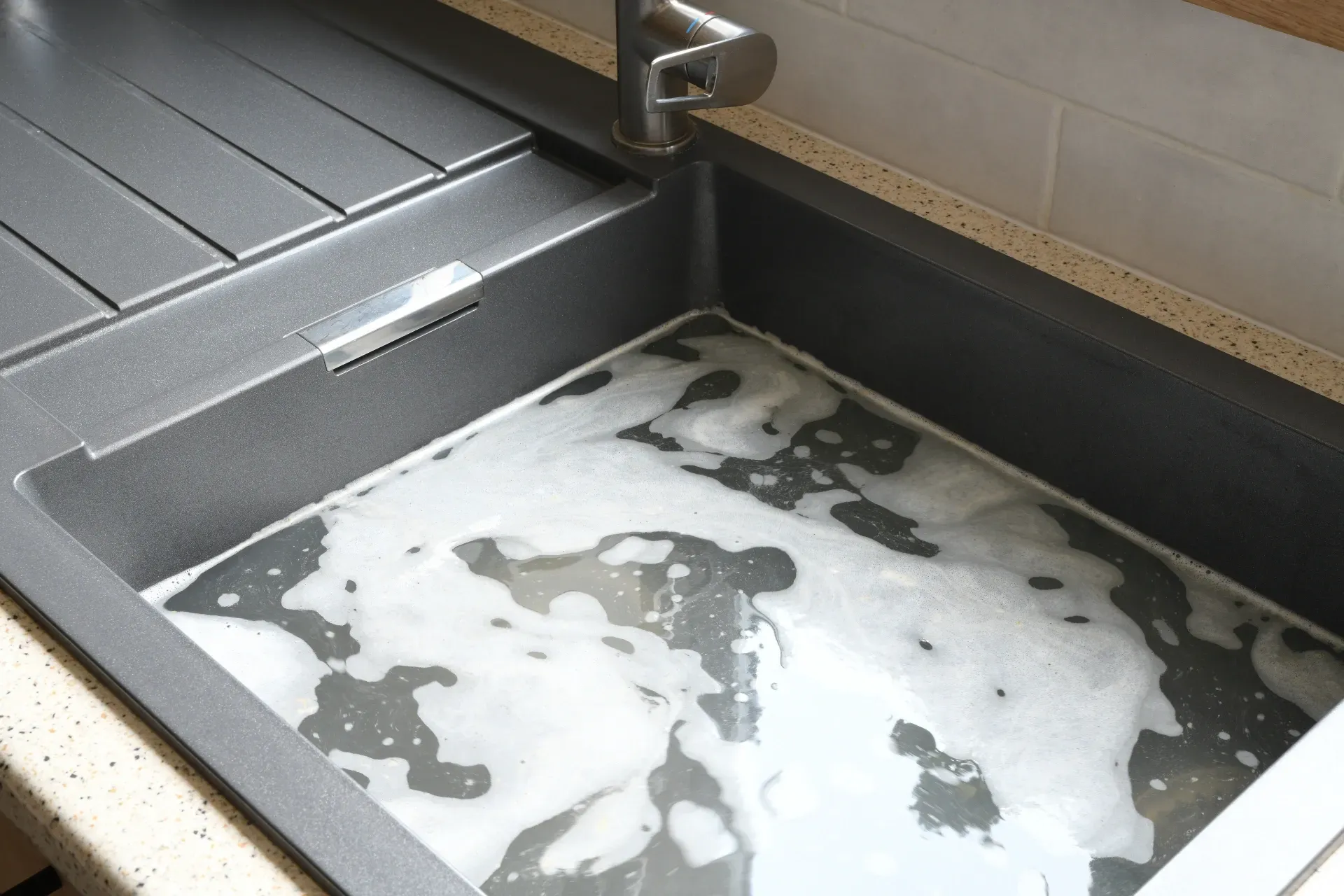 Close-up of a stainless steel sink filled with soapy water and suds — New Gen Plumbing and Gas in Pottsville, NSW