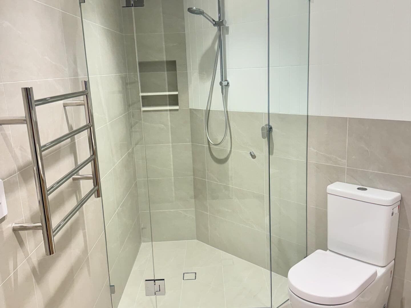 Modern bathroom with walk-in shower, glass enclosure, toilet, and wall-mounted towel rack — New Gen Plumbing and Gas in Pottsville, NSW