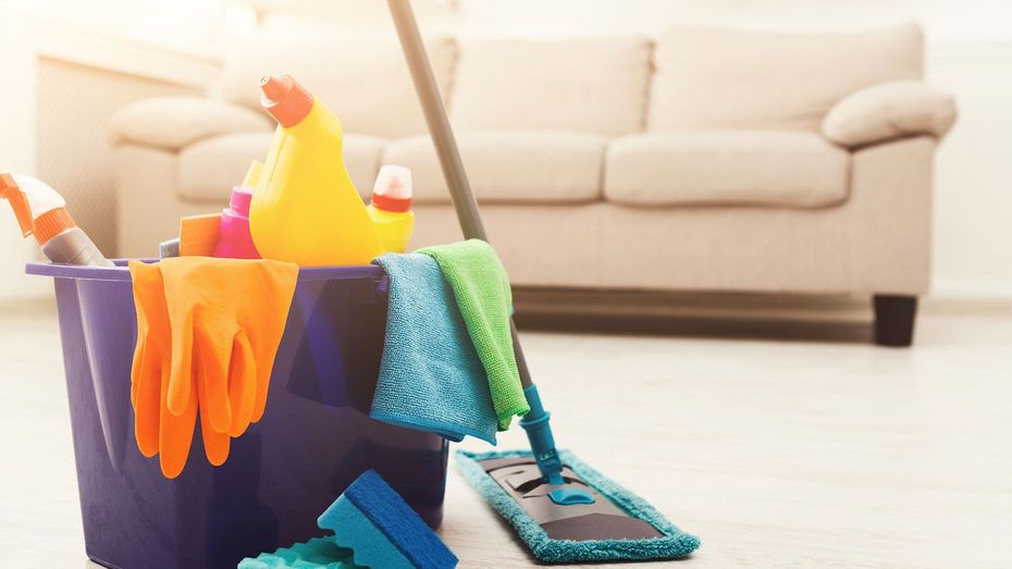 A bucket filled with cleaning supplies and a mop in a living room.