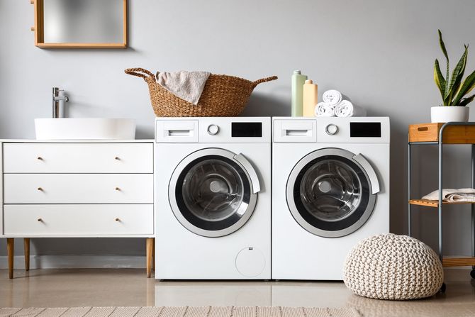 A bathroom with two washing machines and a sink.