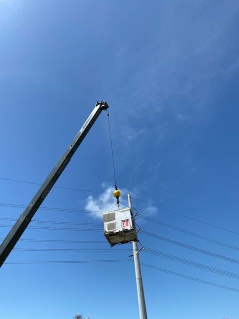 A man on a ladder is working on the ceiling of a building.