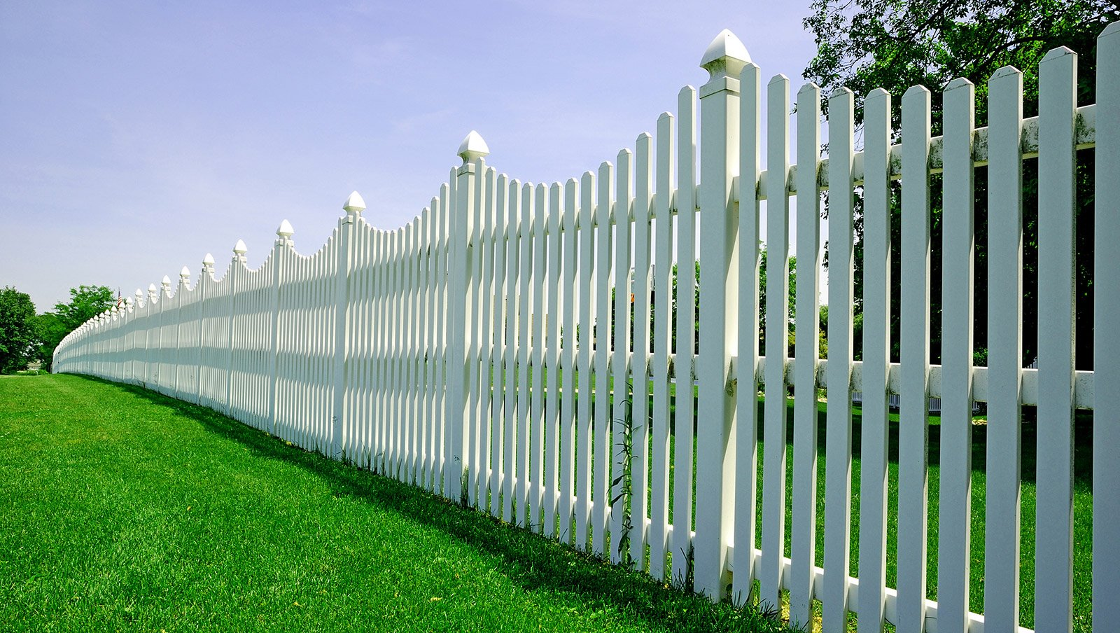 Long white residential fence and grass