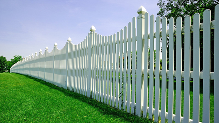 Long white residential fence and grass