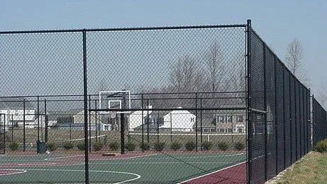 Black chain link fence surrounding basketball court