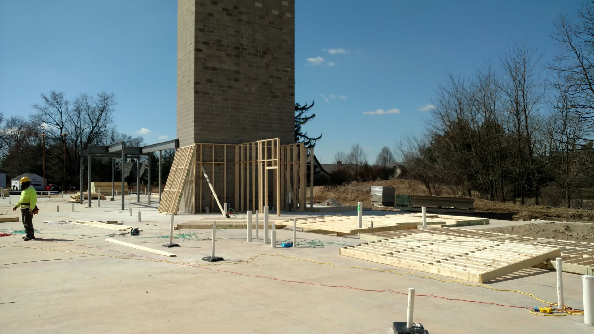 A construction site with a large brick chimney in the background.