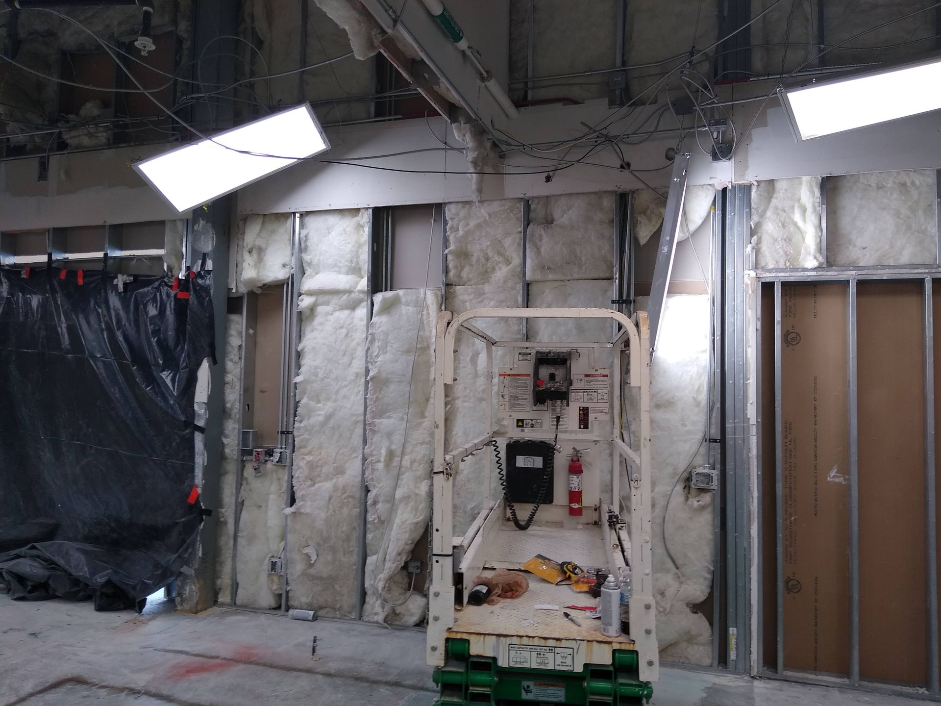 A forklift is sitting in a room with a lot of insulation on the walls.