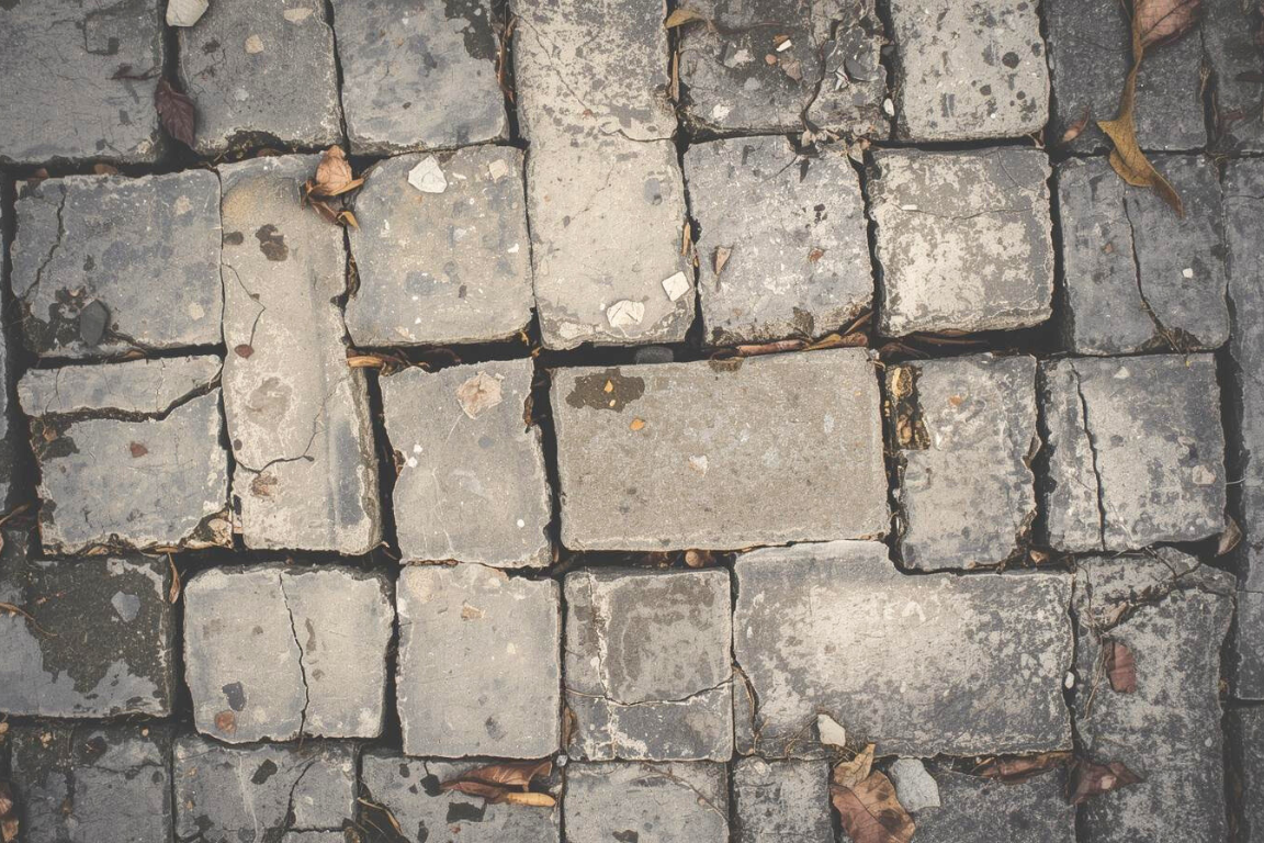 Close-up view of old concrete pavers showing texture and joint spacing.