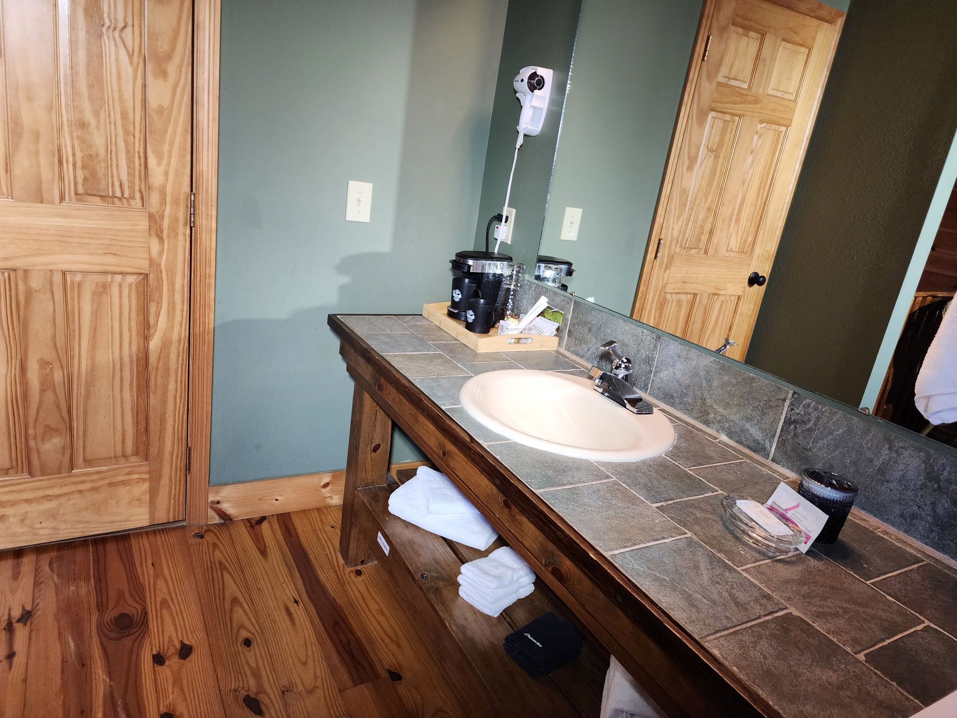 Bathroom with wooden doors, a rustic vanity, and a sink.
