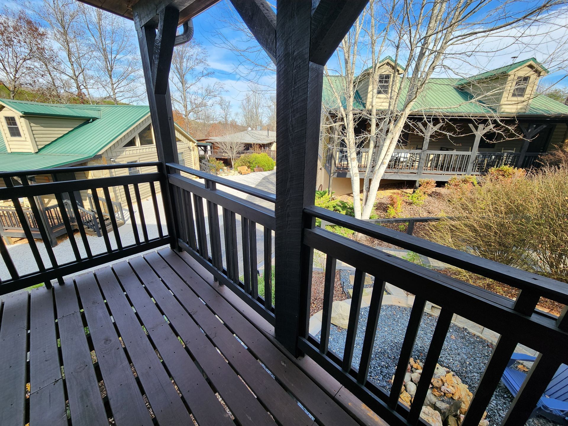 Wooden deck overlooking cabins with green roofs and fall foliage.
