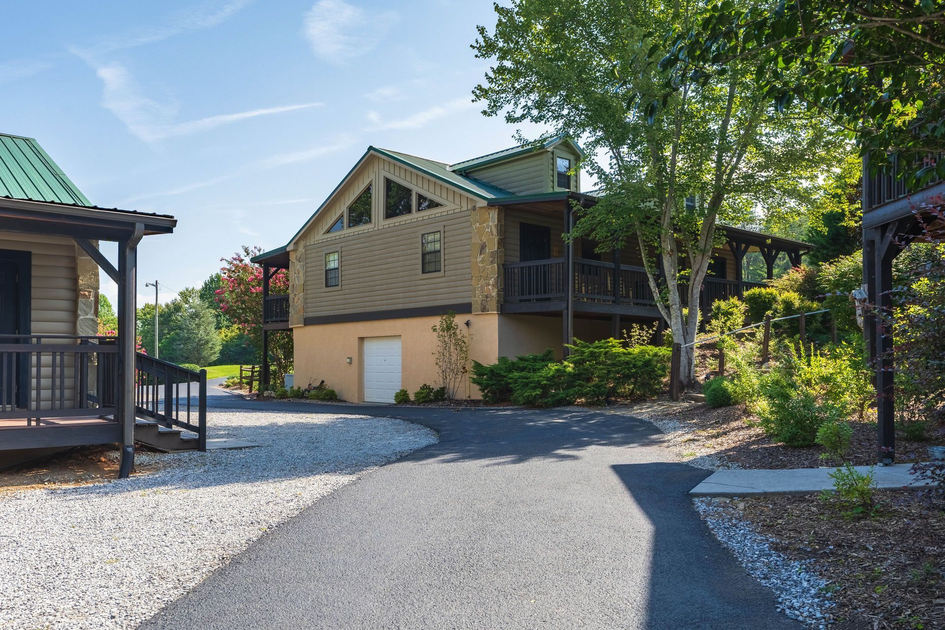 Cottage-style buildings with a central structure connected by a paved pathway; sunny day.