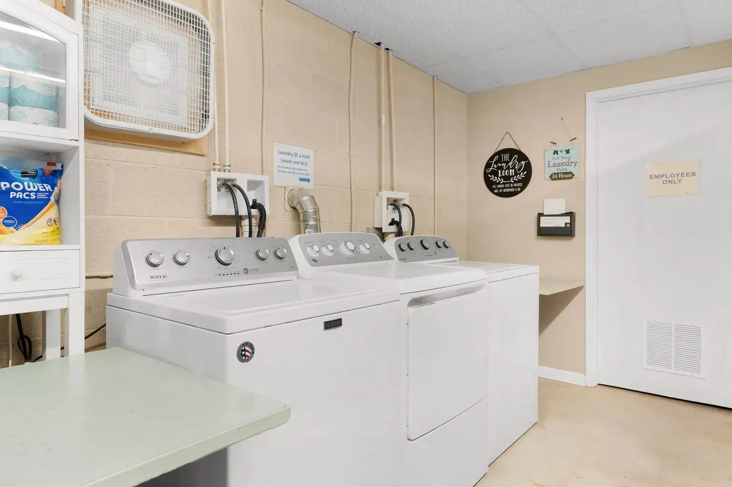 Laundry room with a washing machine, dryer, and storage shelf.