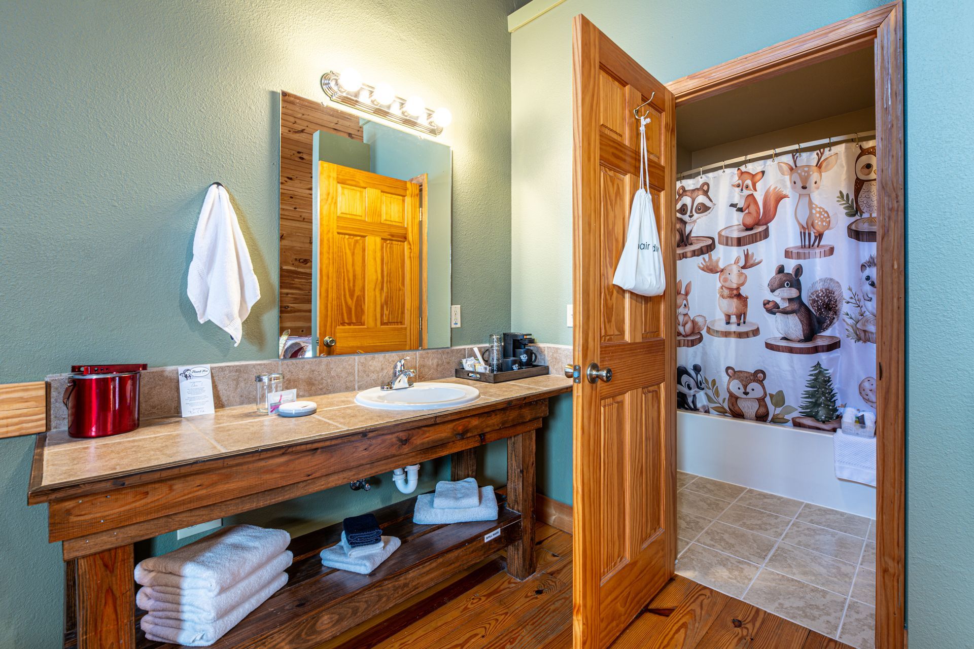 Bathroom with wooden vanity, open door to shower with fox shower curtain.