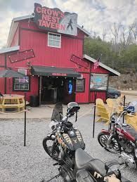 Red building, Crow's Nest Tavern sign, motorcycles parked out front.